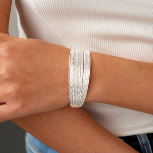 Macro view of multi-layer silver wire bangle set with sparkling frosted finish