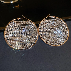 Macro shot of rose gold hoop earrings with sparkling micro-paved crystals on dark background