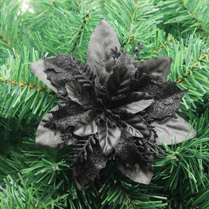 Close-up of triple-layered black glitter artificial poinsettia on Christmas tree branches
