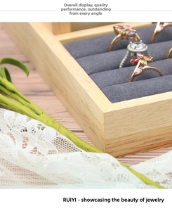 Detailed view of bamboo wood jewelry tray with grey velvet slots for rings storage