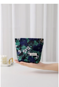 Detailed macro shot of vintage floral jacquard pouch with golden flower charm