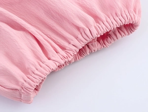 Close-up of pink dress waist elastic band with soft pleats and cotton linen texture