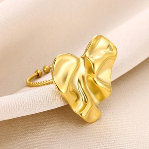 Macro shot of gold abstract irregular open ring on silk fabric with metallic texture