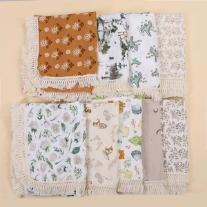 Macro shot of cotton muslin baby blankets with fringe edges and diverse nursery prints