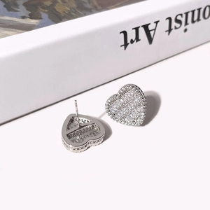 Close-up of silver heart earrings with shimmering pave-set zirconia on a book