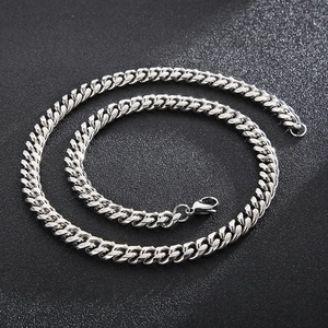 Close-up of silver titanium steel Cuban chain necklace with lobster clasp on dark background