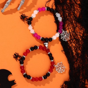 Detail of Halloween spider bracelets with magnetic hearts and beads on festive background