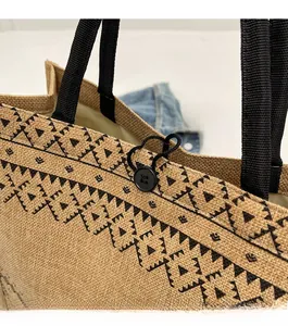 Close-up of linen tote bag with geometric print and button elastic closure detail
