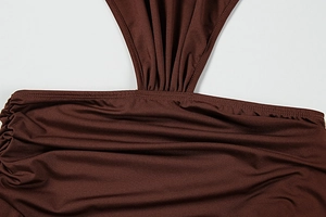 Detailed macro view of brown ruched dress showing elastic fabric and fine stitching