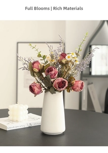 Detail of vintage faux rose and daisy bouquet in white ceramic vase on a dark table
