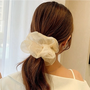 Close-up of champagne organza oversized scrunchie worn on hair with soft texture