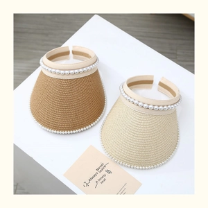 Detail of woven straw sun hat with pearls in dark coffee and cream colors