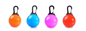 Detailed view of LED pet safety pendants in four vibrant colors with metal clips