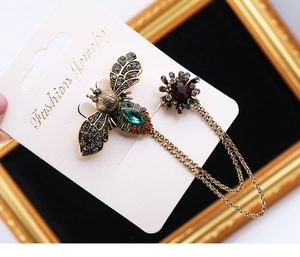 Detailed view of vintage bronze bee and flower brooch set with double layer chains