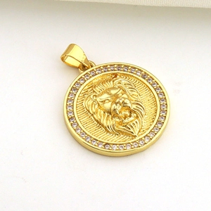 Macro shot of gold sun-shaped pendant with lion head relief and cubic zirconia border