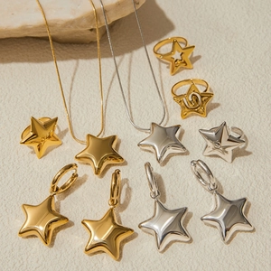 Set di gioielli a stella in oro e argento con collana, orecchini e anello su pietra