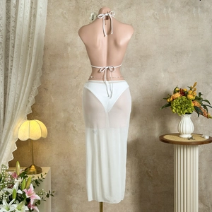 Back view of a white three-piece bikini set with a long sheer mesh beach skirt on a mannequin
