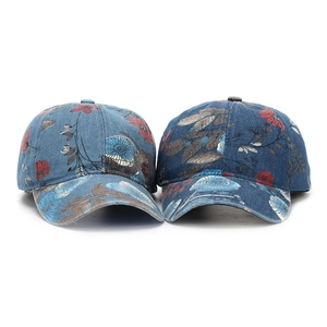 Detail of two denim baseball caps featuring vintage floral patterns in dark and light blue