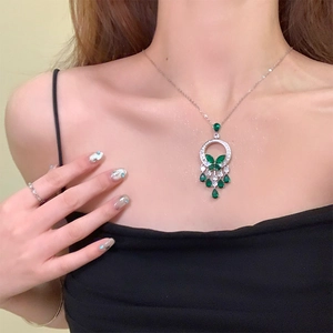 Élégant collier en argent avec pierre émeraude et pendentif à pampilles sur un mannequin