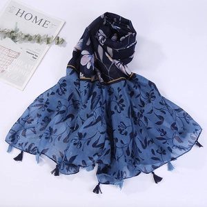 Detail of floral print scarf with soft fringe tassels and navy blue patchwork design