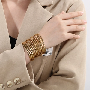 Retro gold layered bangle set with geometric textures on polished stainless steel