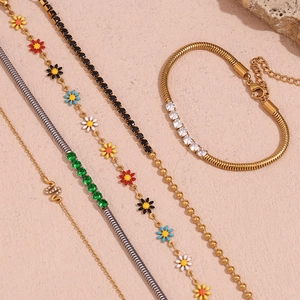 Gros plan de bracelets en or et argent avec micro-zircons et breloques de marguerites