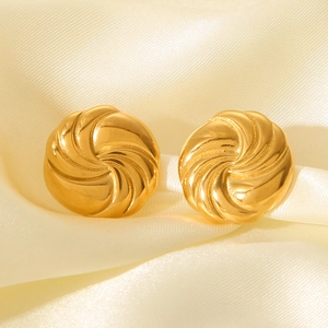 Golden round swirl earrings with spiral texture on elegant silk background