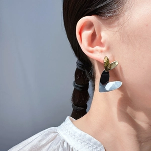 Minimalist heart earrings in gold and silver contrast on model with trendy geometric design