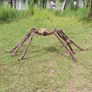 Giant plush Halloween spider with glowing red eyes and purple LED lights for garden decor