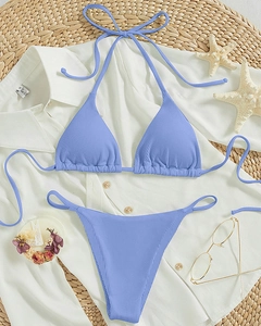Flat lay of periwinkle ribbed halter bikini set with starfish and seashell decor