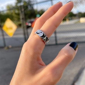 Detailed view of silver titanium ring with moon and star pattern worn on finger