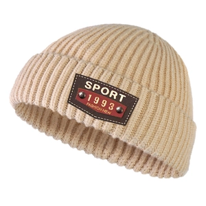Detailed macro view of the knitted beanie texture with leather sport tag and rivets