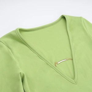 Détail du décolleté en V profond avec chaîne dorée sur cette robe vert citron