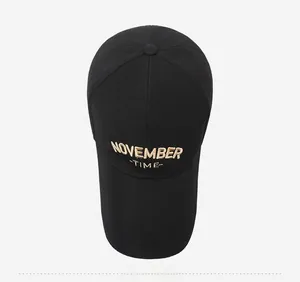 Top view of black cotton baseball cap showing November Time embroidery and six-panel crown
