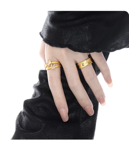 Detail of gold double-layer band ring with rectangle zircon and textured purple stone ring