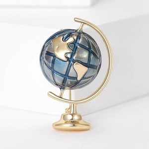 Detailed close-up of a globe brooch with gold metal frame and dark blue globe sphere