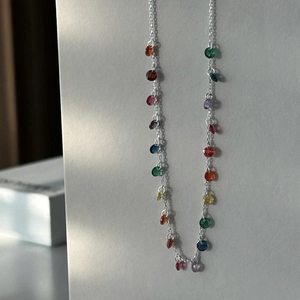 Close-up of 925 sterling silver chain necklace with multi-color transparent gemstones