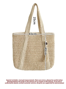 Detail of large straw tote bag featuring decorative fringe and wooden bead tassel ornament