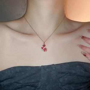 Detail of 18k gold plated necklace with red floral drop pendant on female model