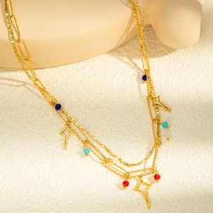 Détail d'un collier multicouche en acier doré avec perles colorées et étoiles ajourées