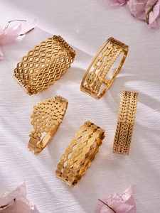 Detailed macro view of vintage style gold-plated textured hollow stainless steel bangles