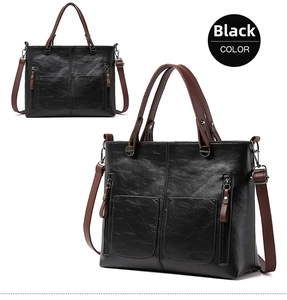 Detailed view of black PU tote bag featuring lychee texture and dual front pockets