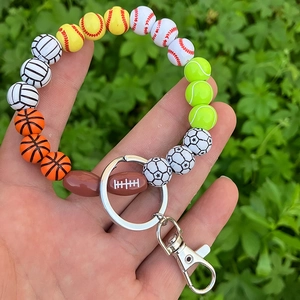 Detailed view of handmade sports beaded wristlet featuring soccer and basketball wood beads