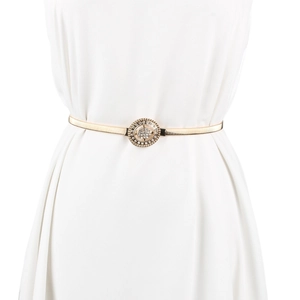 Détail d'une ceinture élastique dorée avec boucle ronde ornée de strass brillants