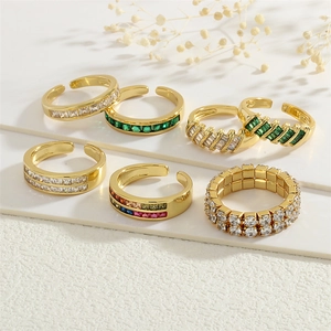 Detailed close-up of 18K gold plated rings set with colorful zircon stones on a white base