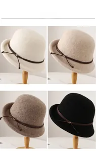 Detail view of four wool bucket hats in beige, white, brown and black with leather straps