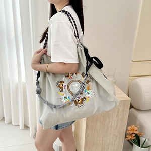 Light grey nylon tote bag with delicate embroidery and drawstring closure