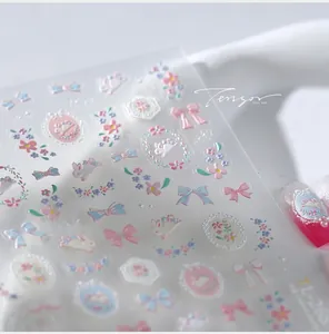 Macro detail of 3D embossed nail stickers featuring blue bows and cute rabbit designs