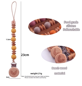 Detail of beech wood pacifier clip with rainbow engraving and food-grade silicone beads
