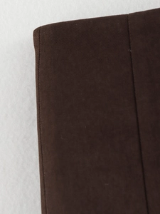 Macro shot of brown knitted fabric texture on a soft white plush background